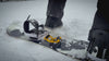 Foot stomping into the Giini device on a snowboard, showing the grip